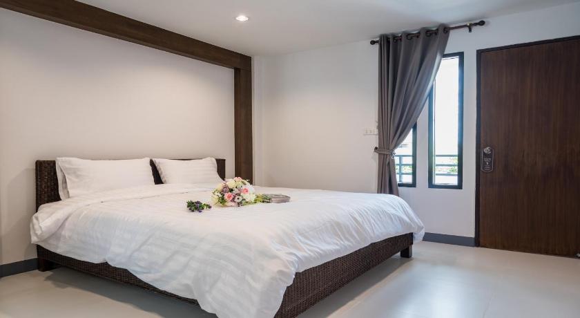 a bedroom with a white bedspread and white pillows, I Doi Hotel in Chiang Rai