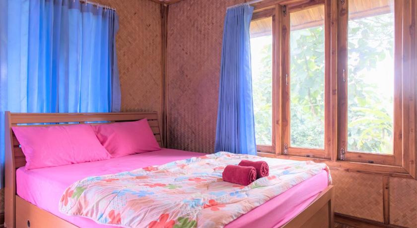 a bed that has a blue blanket on it, Fufu In Love Cottages & Campground in Khao Kho