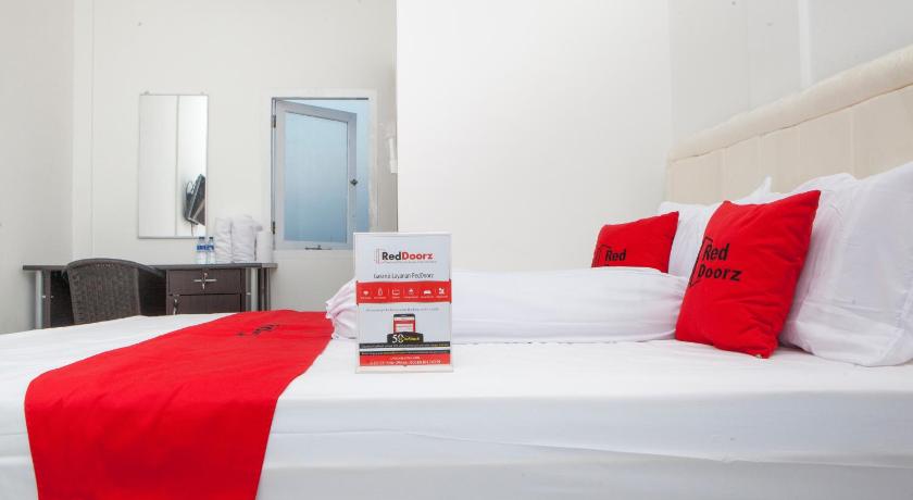 a hotel room with two beds and a white bedspread, RedDoorz near Telkom Corporate University in Bandung
