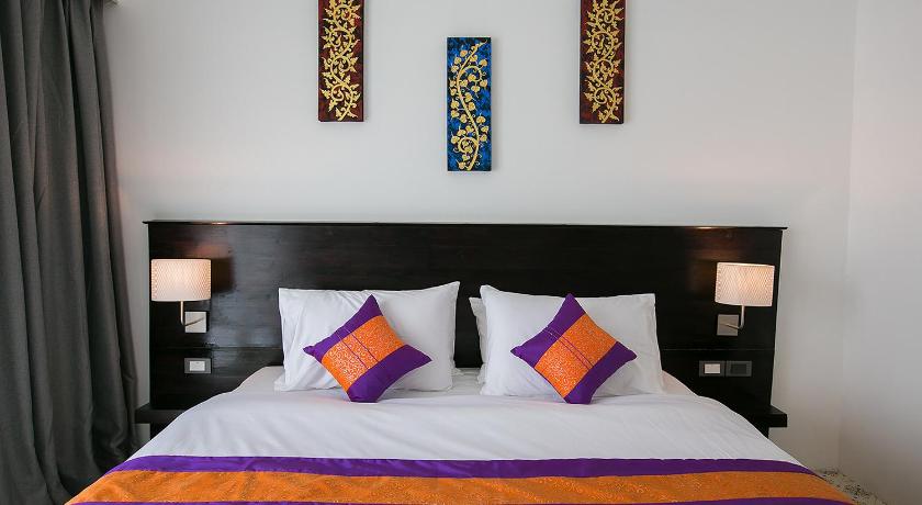 a bed with two pillows and two nightstands, SakSukSmile Resort in Sukhothai