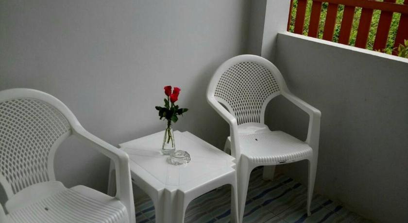 a room with a table, chairs, and a table with a vase, 2N Guesthouse in Phetchaburi