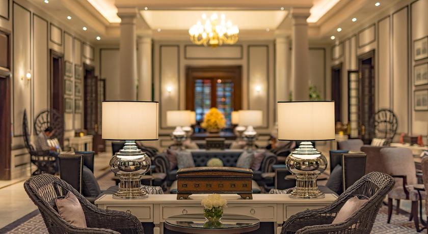a living room filled with tables and chairs, The Strand Yangon in Yangon