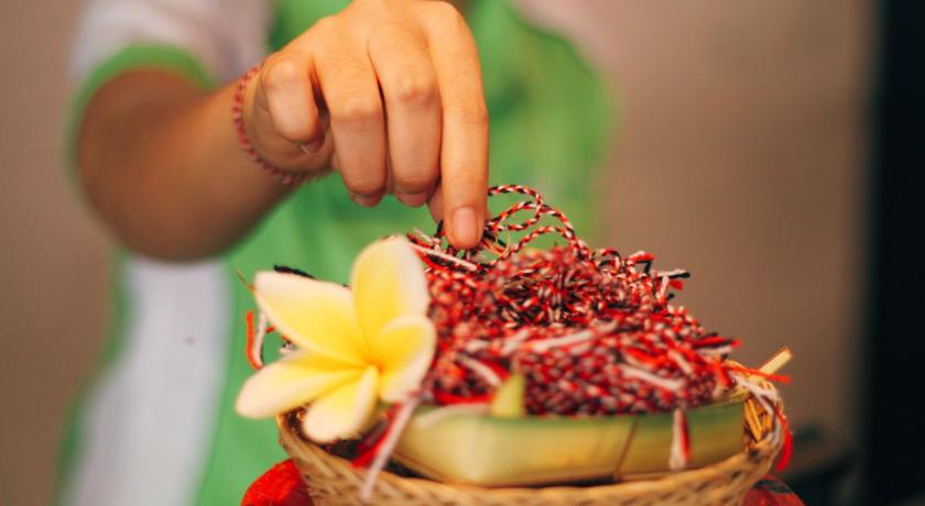 a person holding a basket filled with fruit, Grandmas Plus Hotel Legian in Bali