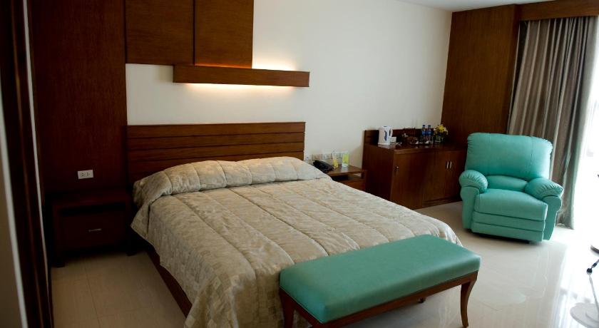 a bedroom with a bed, chair, desk and a lamp, Skinetics Wellness Center and Boutique Hotel in Iloilo