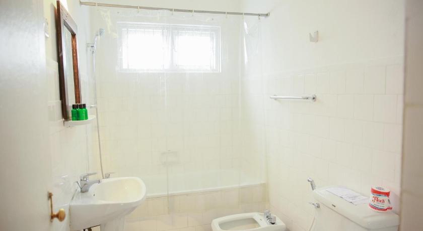 a white toilet sitting next to a sink in a bathroom, Hotel Glendower in Nuwara Eliya