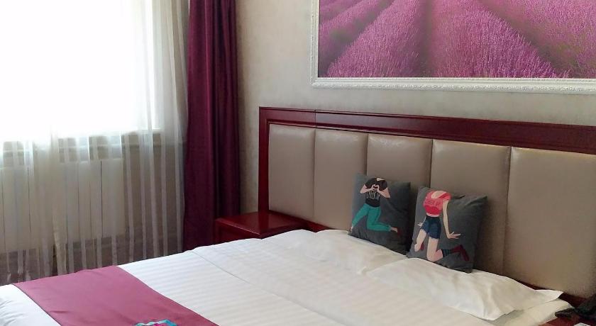 a bed in a bedroom with a picture on the wall, Pai Hotel Beijing Beiyuan Subway Station in Beijing