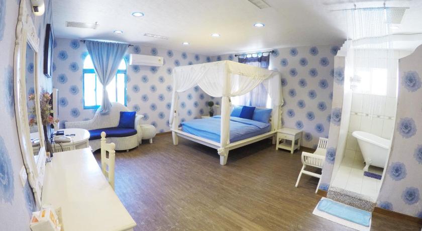 a room with a bed, a chair, and a window, Blue Sea Inn in Kenting