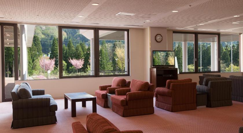 a living room filled with furniture and a large window, Tateyama Kokusai Hotel in Toyama