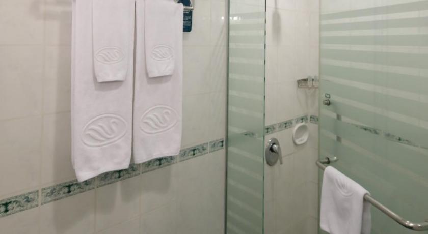 a bathroom with a shower stall with towels hanging on the wall, Sunway Hotel in Hanoi