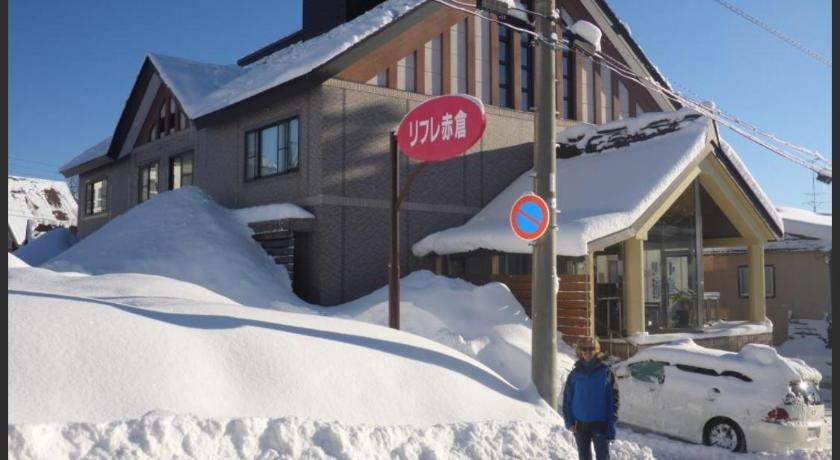 a person standing in front of a snow covered ski slope, Refre Hotel in Itoigawa