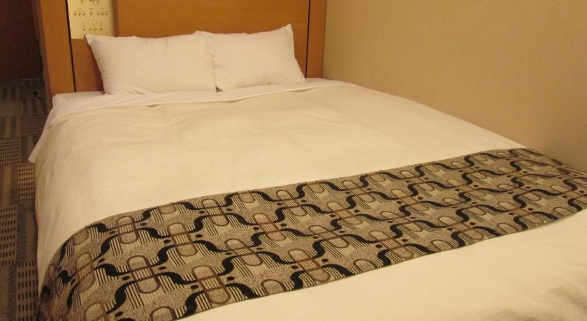 a bed with a white comforter and pillows, Yamagataeki Nishiguchi Washington Hotel in Yamagata