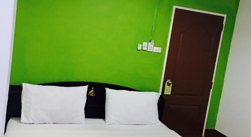 a room with a bed, a desk, and a painting on the wall, Lucky Guest House in Ko Phi Phi
