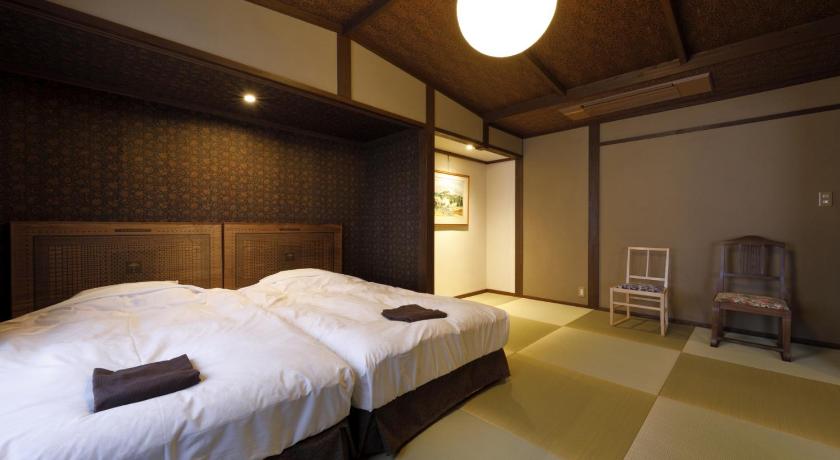 a hotel room with a bed and two lamps, Yufuin Souan Kosumosu in Yufu