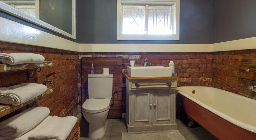 a bathroom with a toilet, sink and tub, Carrington Guest House in Durban