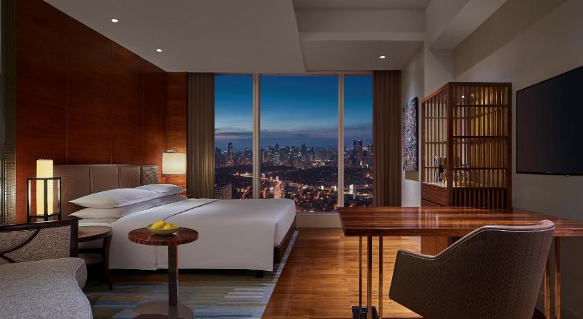 a living room filled with furniture and a large window, Grand Hyatt Manila  in Manila