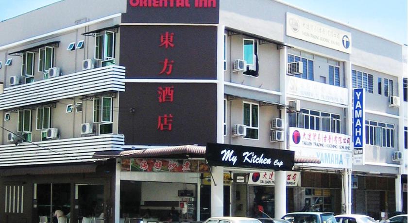 a large building with a sign on the side of it, Oriental Inn in Kuching