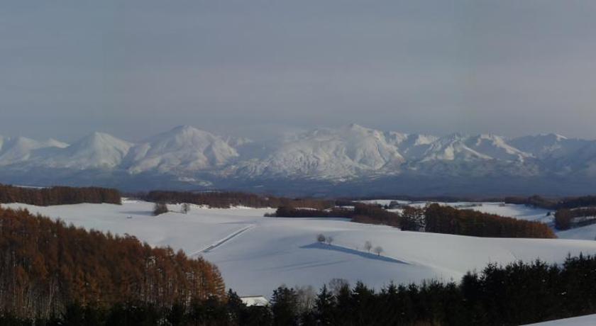 a mountain range with snow capped mountains, Coro Coro in Furano