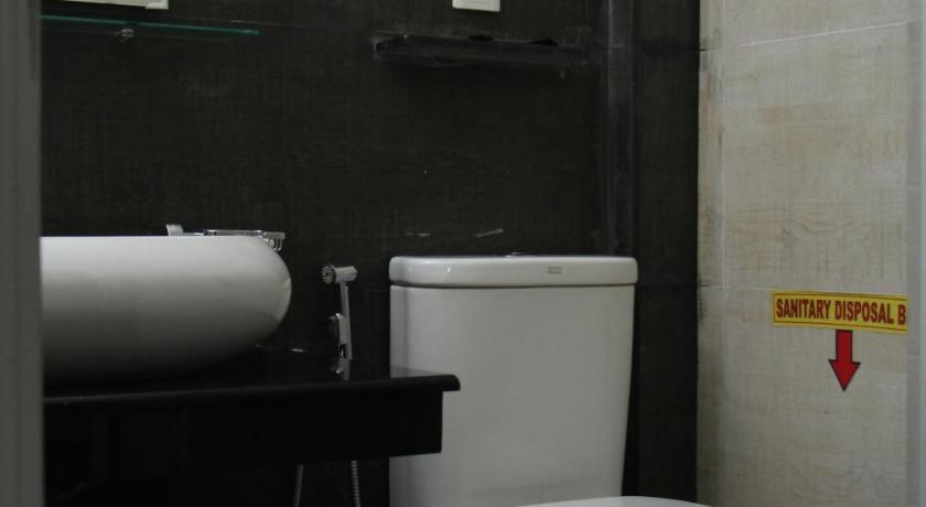 a white toilet sitting in a bathroom next to a sink, Misty Paradise of Lake Gregory in Nuwara Eliya