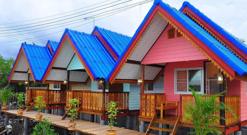 a row of wooden tables with colorful umbrellas, Sampaongern Home Stay in Phetchaburi