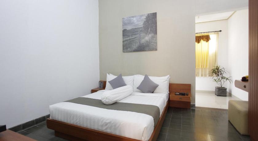 a hotel room with a bed and a desk, Taman Yuwono Heritage Malioboro in Yogyakarta