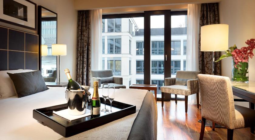 a living room filled with furniture and a large window, Eurostars Berlin in Berlin