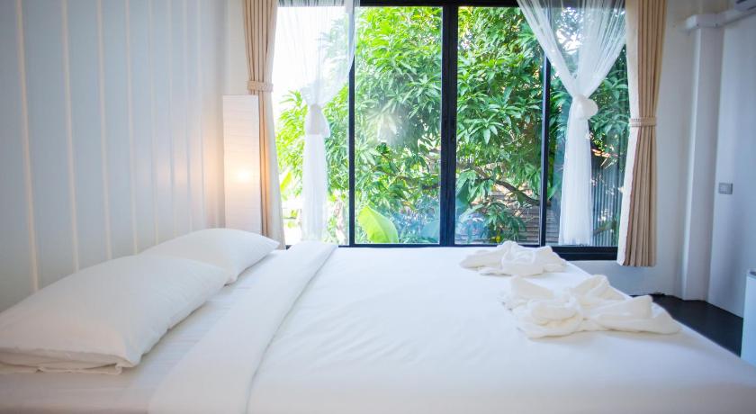 a bedroom with a bed and a window, Trat 101 Hotel (SHA Certified) in Trat