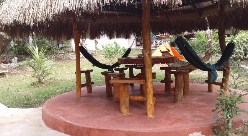 a picnic table with an umbrella on top of it, Chelle's Guesthouse and Backpackers in Siquijor Island