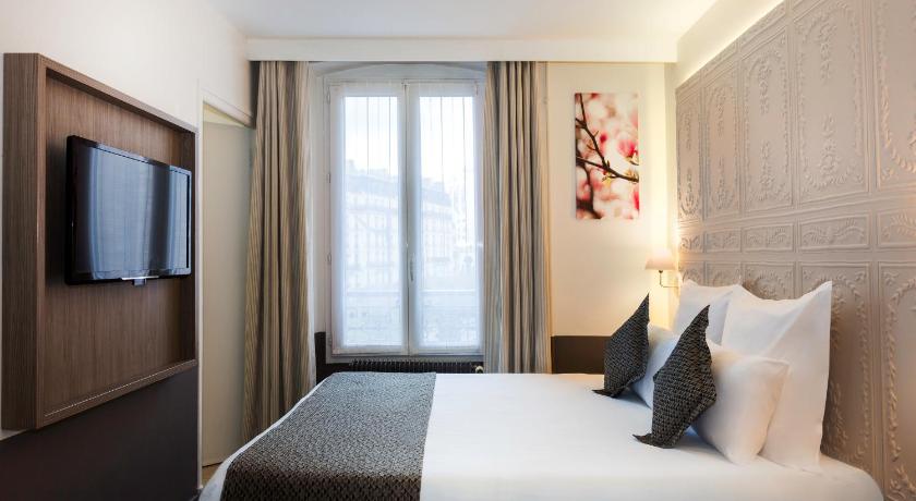 a bedroom with a large bed and a large window, Contact Hotel Alize Montmartre in Paris