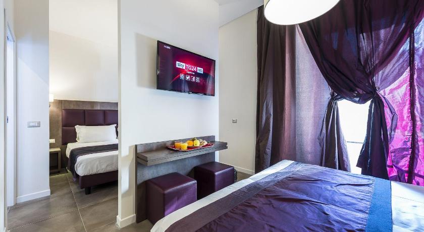 a hotel room with a bed, television and a lamp, Hotel California in Rome