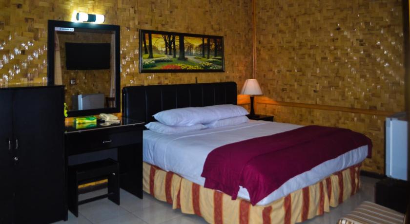 a bedroom with a bed and a desk, Hotel Indra Toraja in Rantepao