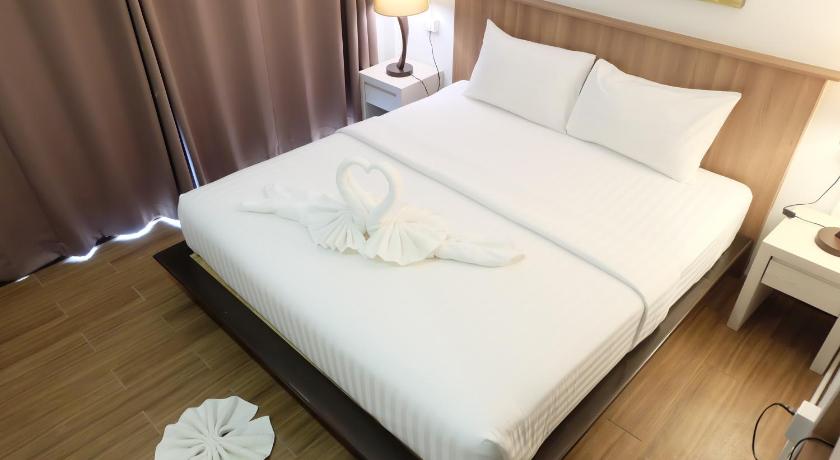 a bed with a white comforter and pillows on it, A Plus Lipe Hotel in Ko Lipe
