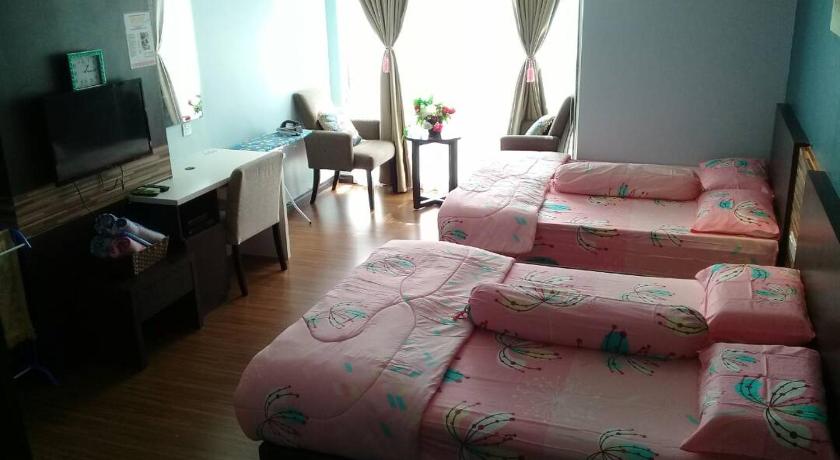 a bed room with two beds and a television, Best Studio Guest House in Kota Bharu