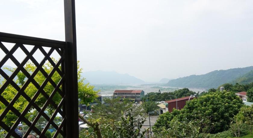 a wooden bench sitting on top of a lush green hillside, Five mountains and Three Water B&B in Nantou