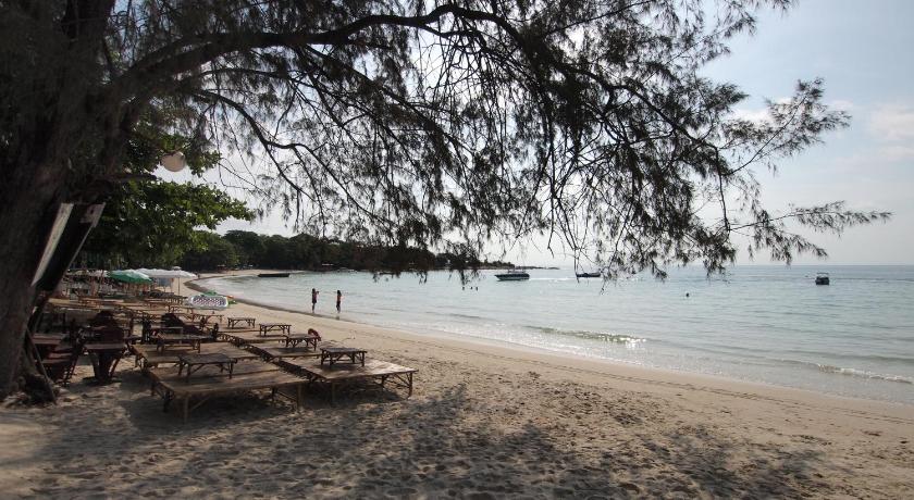 a sandy beach with trees and palm trees, Crescent Bay Resort in Ko Samet