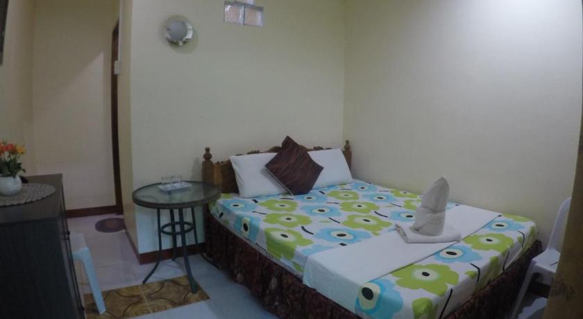 a bedroom with a bed and a dresser, D Lucky Garden Inn and Suites in Palawan