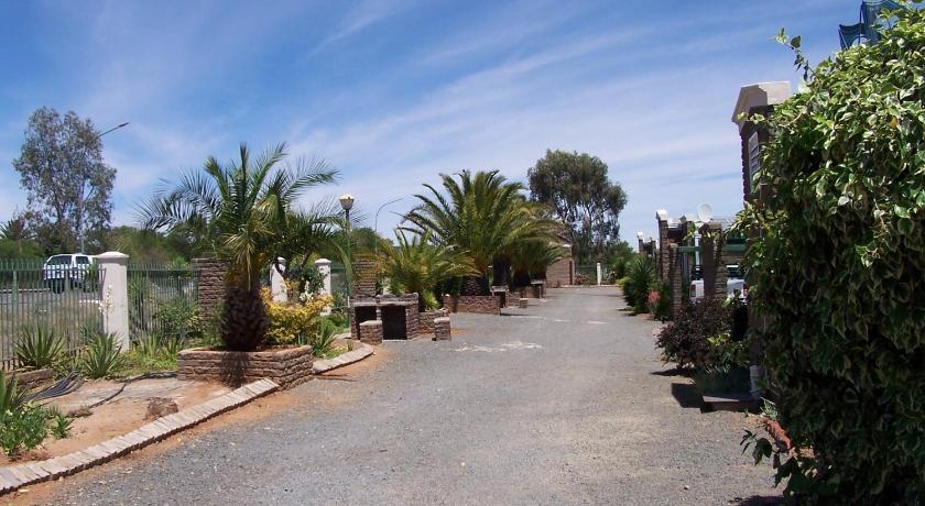 a street lined with palm trees and palm trees, Gables Inn in Colesberg