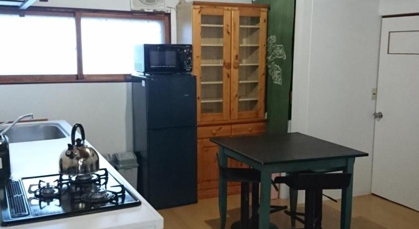 a kitchen with a table, chairs and a refrigerator, Yukiyama Chalet Apartments in Furano