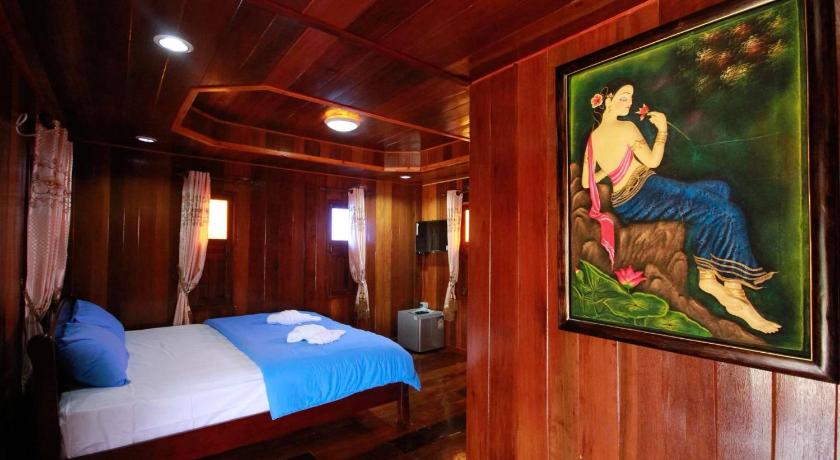 a bed room with a painting on the wall, Maderbua hotel in Udon Thani