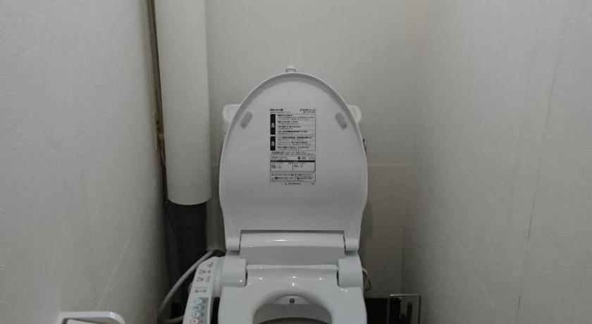 a white toilet sitting in a bathroom next to a window, Yukiyama Chalet Apartments in Furano
