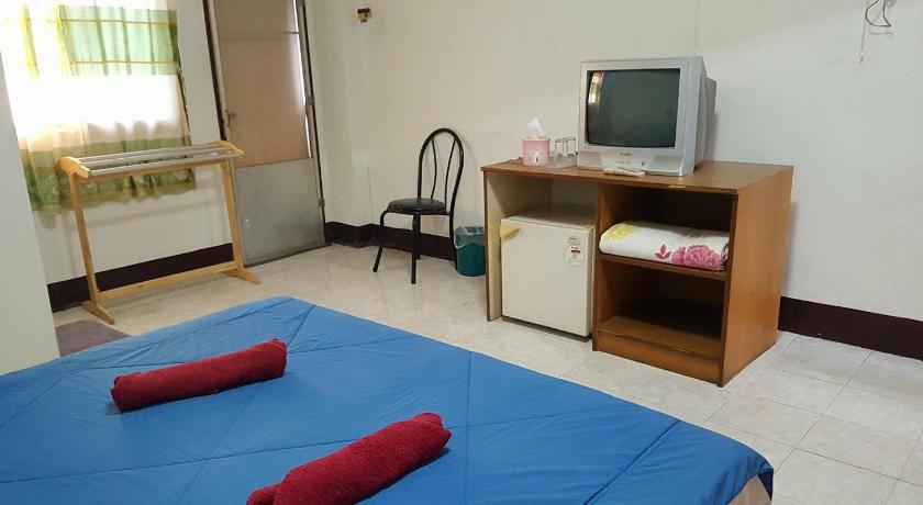 a bedroom with a bed and a television, LP Apartment in Sakon Nakhon