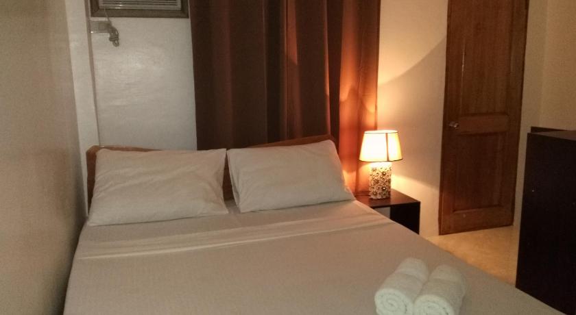 a hotel room with a bed and a lamp, Zenith Inn & Resto Bar in Bohol