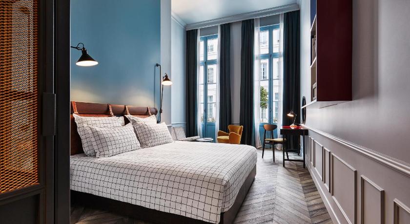 a bedroom with a large bed and a large window, The Hoxton - Paris in Paris