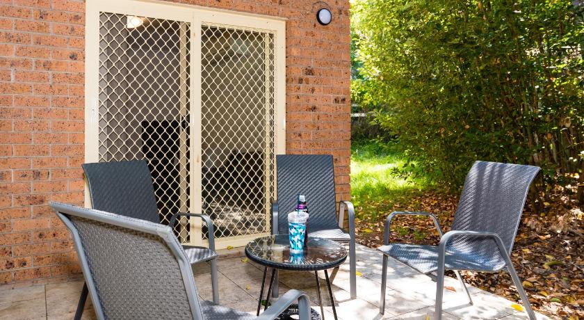 a dining room table with chairs and a patio, Eastwood Furnished Apartments in Sydney