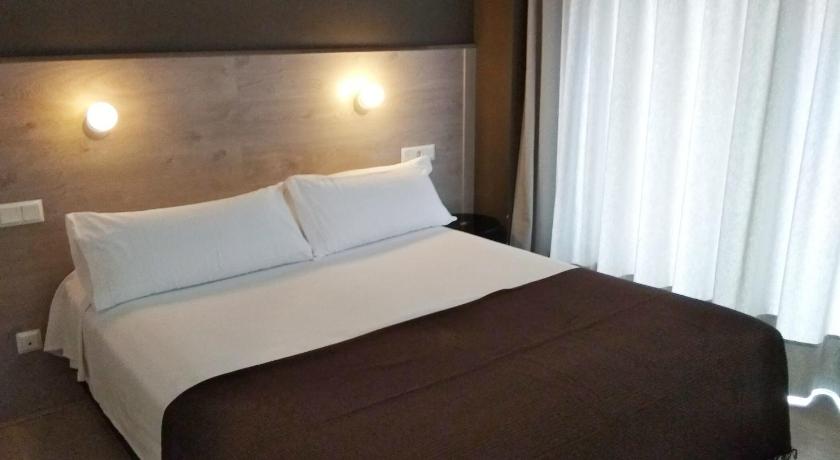 a hotel room with a large bed and a large window, Hotel Delicias in Zaragoza