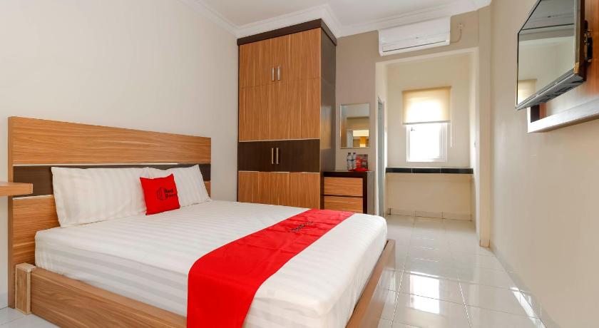 a hotel room with a bed and a desk, RedDoorz Plus near Palembang Square Mall in Palembang