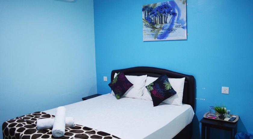 a bed in a room with a blue wall, Hotel SN Legacy in Kuala Terengganu