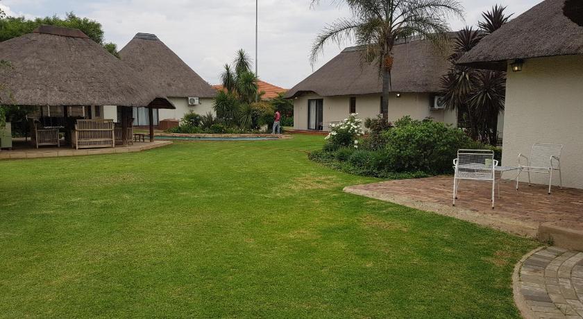 a large white house sitting in the middle of a grassy area, 12 On Vaal Drive Guesthouse in Vanderbijlpark