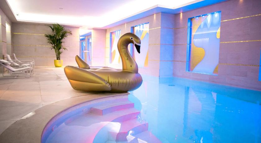 a statue of a duck sitting on top of a swimming pool, Le Burgundy Paris                                                                            in Paris