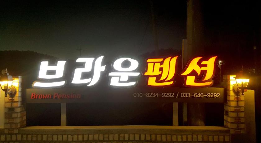 a neon sign on a pole at night, Brown Pension in Gangneung-si