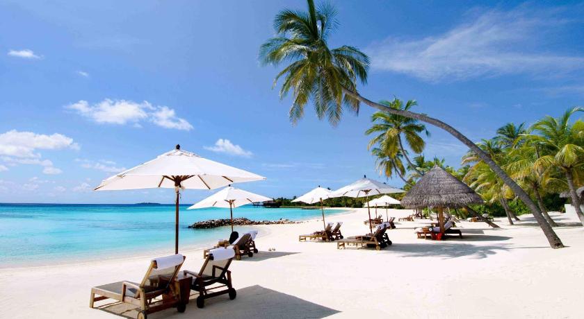 a beach area with chairs, tables and umbrellas, Alana Nha Trang Beach Hotel in Nha Trang